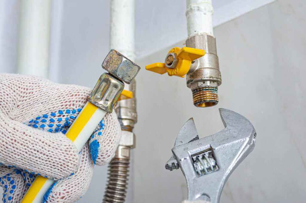 A technician is replacing or connecting a gas pipe.