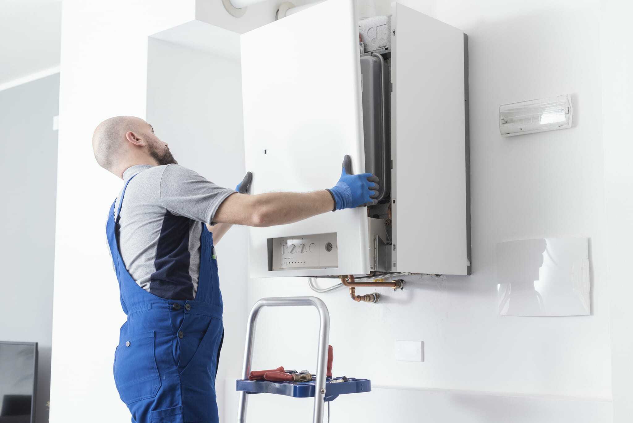 HVAC technician replacing the front faceplate of a residential boiler 