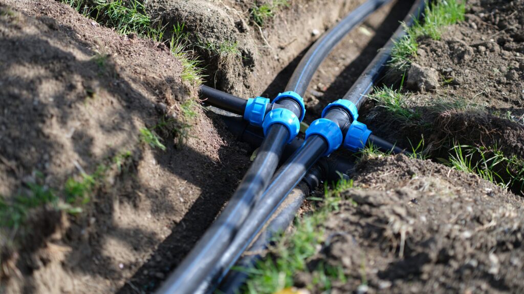 Installed PVC water pipes in trench at summer cottage. Plumbing system outside home concept